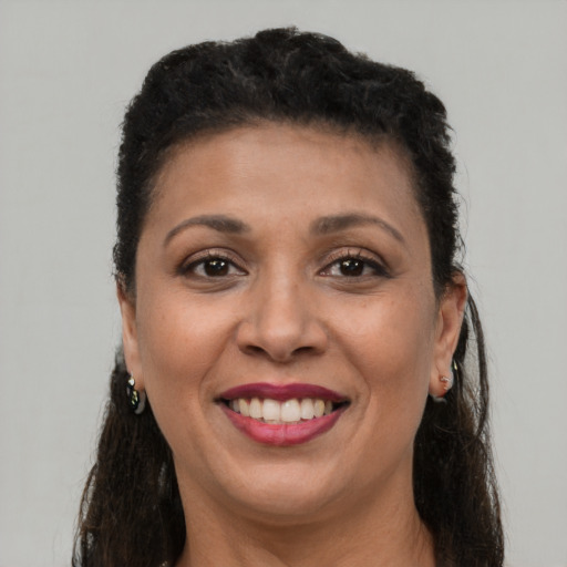 Joyful black young-adult female with long  brown hair and brown eyes
