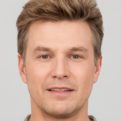 Joyful white adult male with short  brown hair and grey eyes