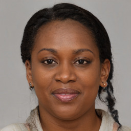 Joyful black adult female with medium  brown hair and brown eyes