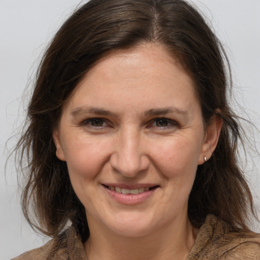 Joyful white adult female with medium  brown hair and grey eyes