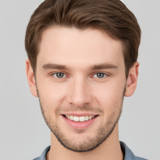 Joyful white young-adult male with short  brown hair and grey eyes