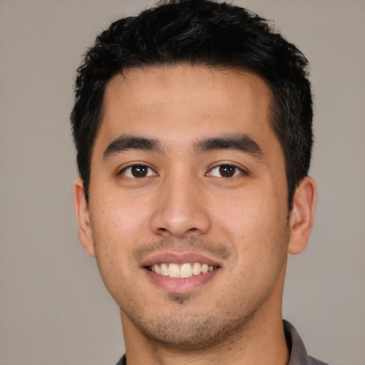 Joyful latino young-adult male with short  black hair and brown eyes