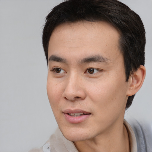 Joyful white young-adult male with short  black hair and brown eyes