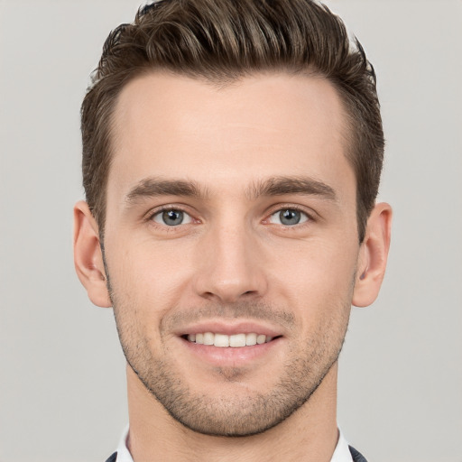 Joyful white young-adult male with short  brown hair and grey eyes