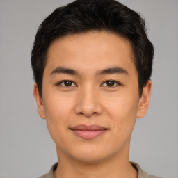 Joyful asian young-adult male with short  brown hair and brown eyes