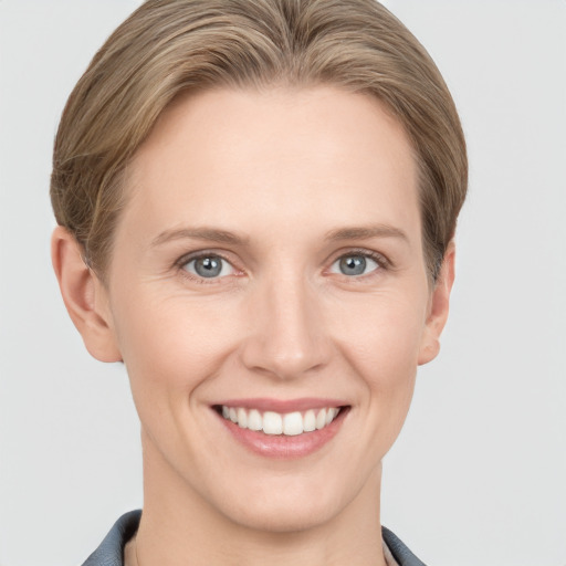 Joyful white young-adult female with short  brown hair and grey eyes