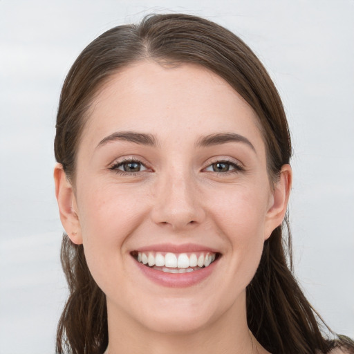 Joyful white young-adult female with long  brown hair and grey eyes