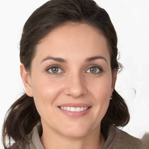 Joyful white young-adult female with medium  brown hair and grey eyes