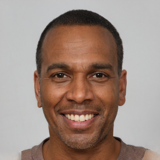 Joyful black adult male with short  black hair and brown eyes