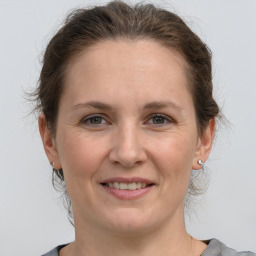 Joyful white adult female with medium  brown hair and grey eyes