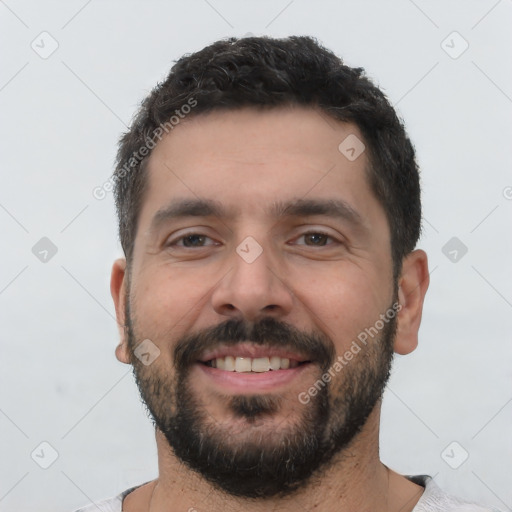 Joyful white young-adult male with short  black hair and brown eyes