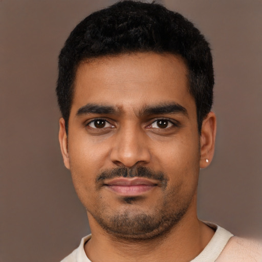 Joyful black young-adult male with short  black hair and brown eyes