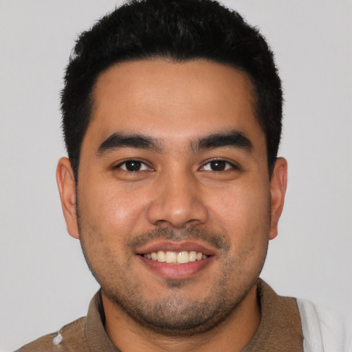 Joyful latino young-adult male with short  black hair and brown eyes