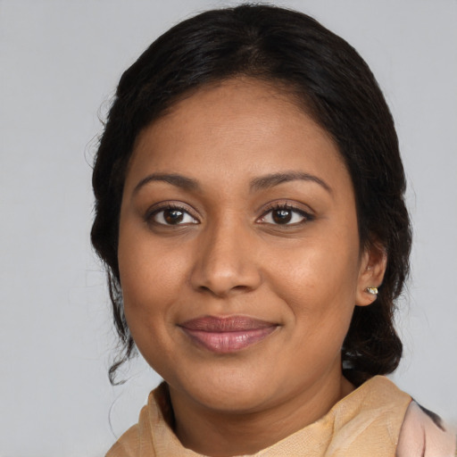 Joyful black young-adult female with medium  brown hair and brown eyes