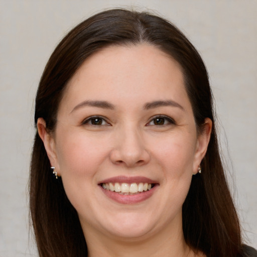 Joyful white young-adult female with long  brown hair and brown eyes