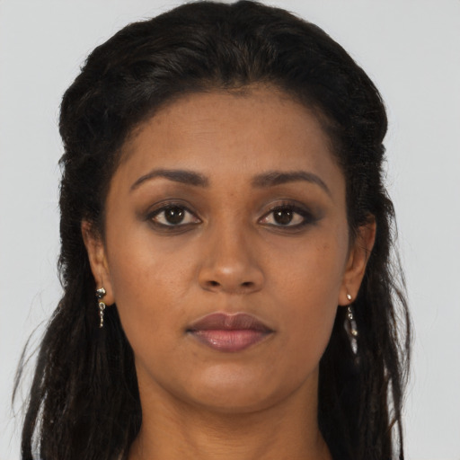 Joyful black young-adult female with long  brown hair and brown eyes