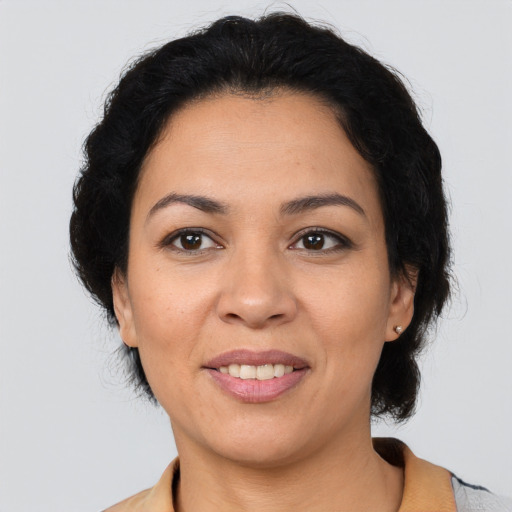 Joyful latino adult female with medium  brown hair and brown eyes