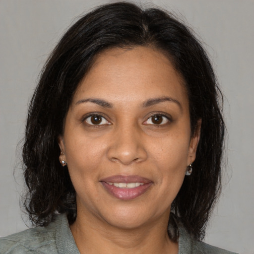 Joyful black adult female with medium  brown hair and brown eyes