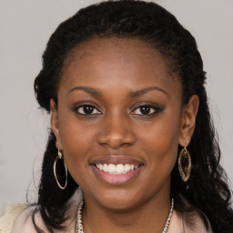 Joyful black young-adult female with long  brown hair and brown eyes