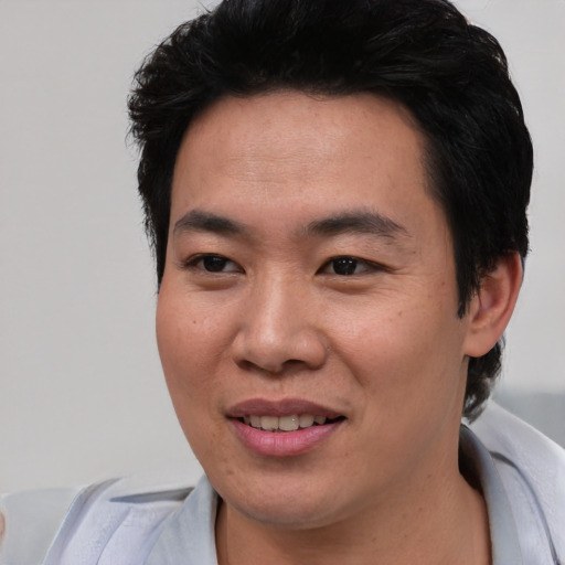 Joyful asian young-adult male with short  black hair and brown eyes