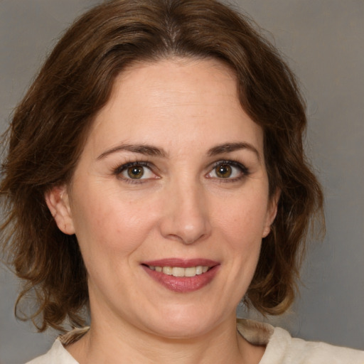 Joyful white adult female with medium  brown hair and brown eyes