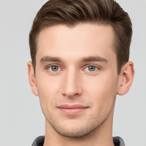 Joyful white young-adult male with short  brown hair and grey eyes