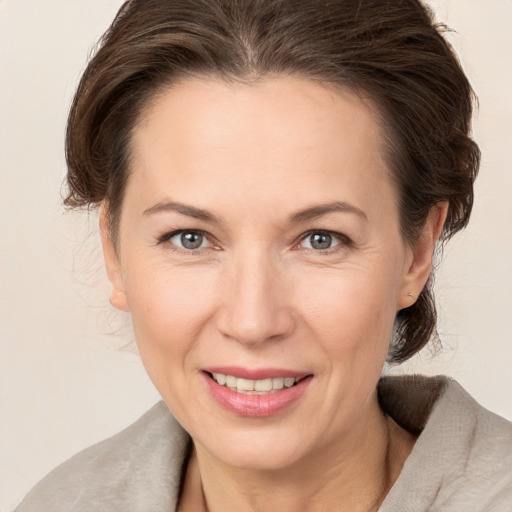 Joyful white adult female with medium  brown hair and brown eyes