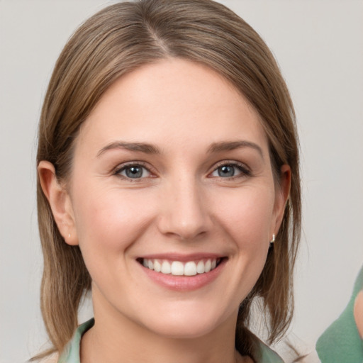 Joyful white young-adult female with medium  brown hair and grey eyes