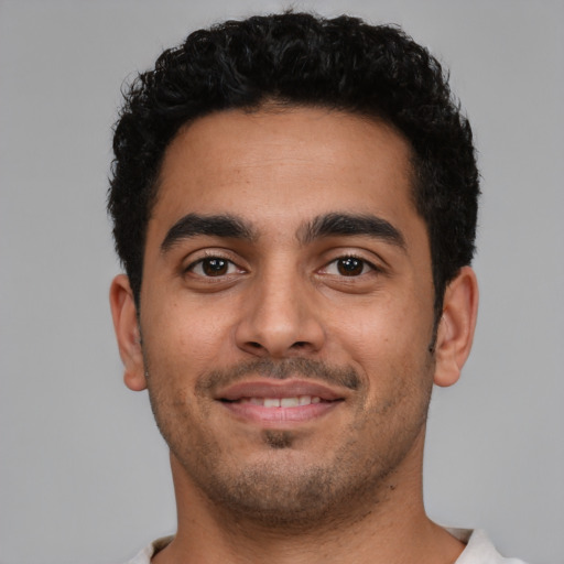 Joyful latino young-adult male with short  black hair and brown eyes