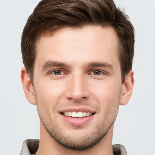 Joyful white young-adult male with short  brown hair and grey eyes