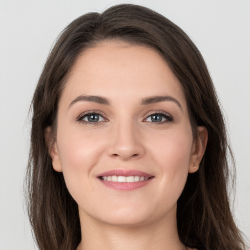 Joyful white young-adult female with long  brown hair and grey eyes