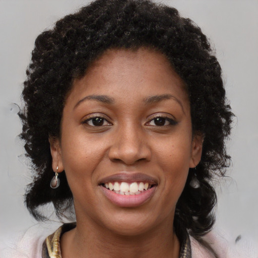 Joyful black young-adult female with long  brown hair and brown eyes