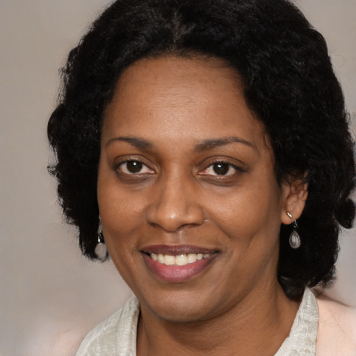 Joyful black adult female with medium  brown hair and brown eyes