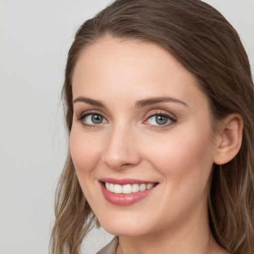 Joyful white young-adult female with long  brown hair and blue eyes