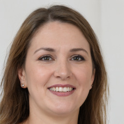 Joyful white young-adult female with long  brown hair and grey eyes