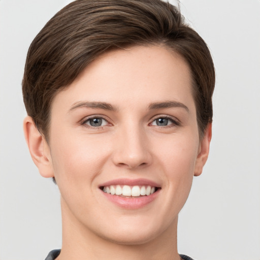 Joyful white young-adult female with short  brown hair and grey eyes