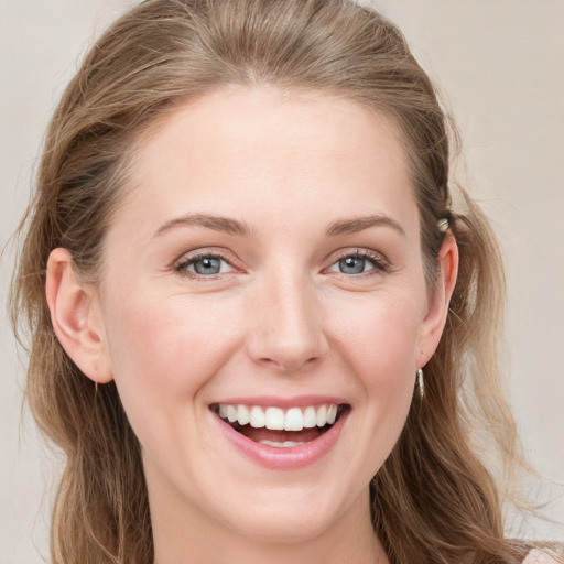 Joyful white young-adult female with long  brown hair and blue eyes