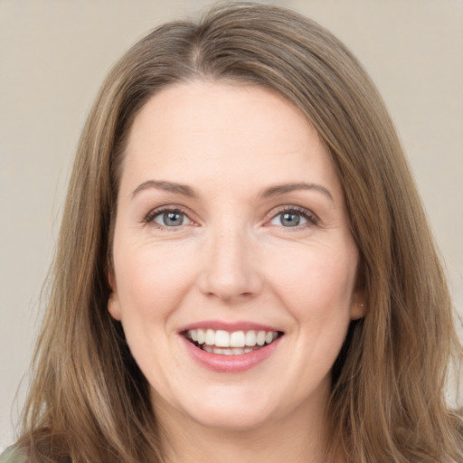 Joyful white young-adult female with long  brown hair and grey eyes