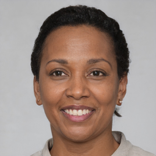 Joyful black adult female with short  brown hair and brown eyes