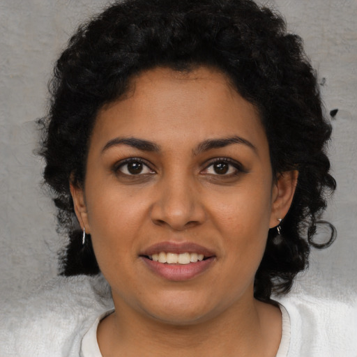Joyful latino young-adult female with short  black hair and brown eyes