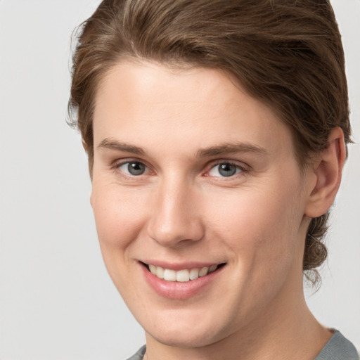 Joyful white young-adult female with short  brown hair and grey eyes