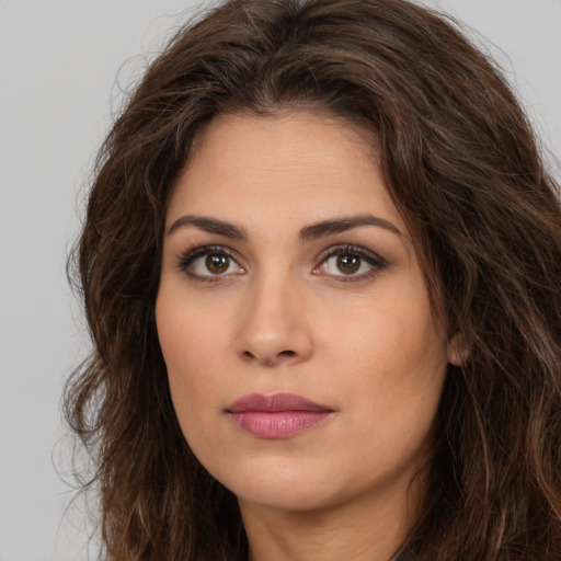 Joyful white young-adult female with long  brown hair and brown eyes