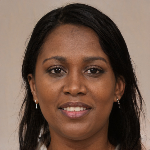 Joyful black young-adult female with long  brown hair and brown eyes