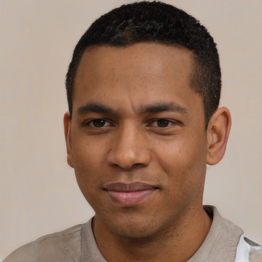 Joyful black young-adult male with short  black hair and brown eyes
