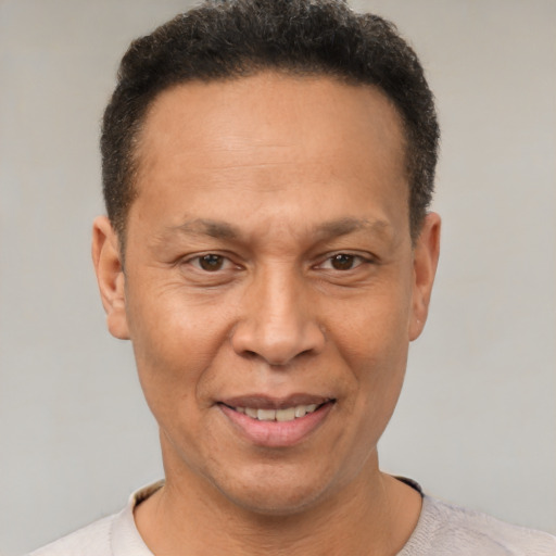 Joyful latino adult male with short  brown hair and brown eyes
