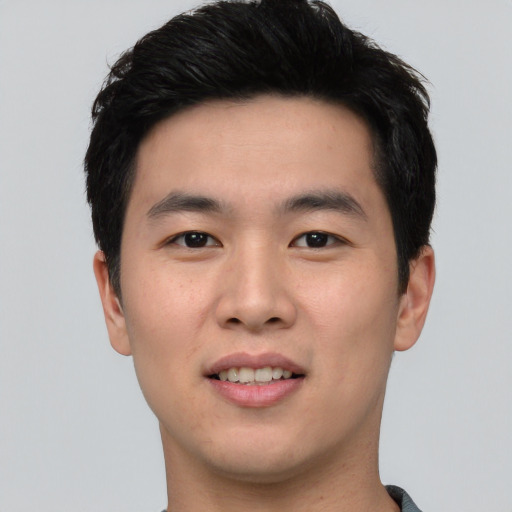 Joyful asian young-adult male with short  black hair and brown eyes