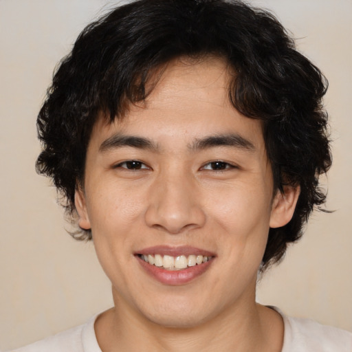 Joyful asian young-adult male with medium  brown hair and brown eyes