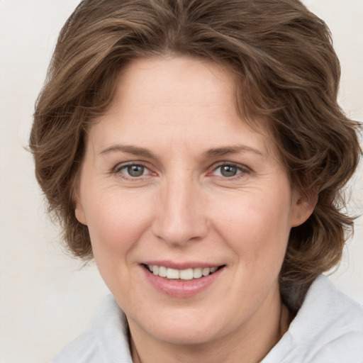 Joyful white adult female with medium  brown hair and grey eyes