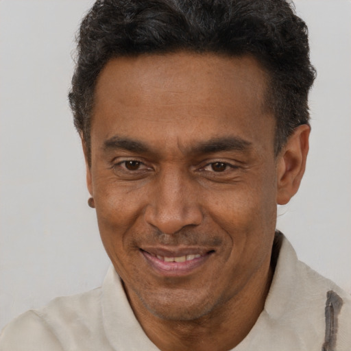 Joyful black adult male with short  brown hair and brown eyes