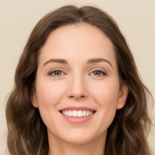 Joyful white young-adult female with long  brown hair and green eyes